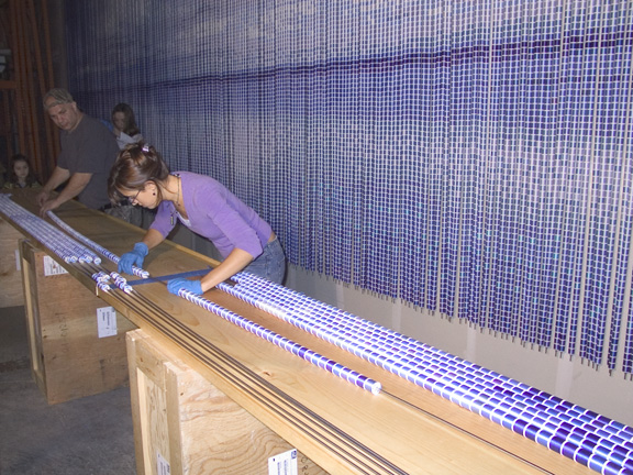 Markertek Warehouse, Saugerties, NY.  Reflections by Devorah Sperber, Assistants transferring spools of thread onto stainless steel tubes, October 2004